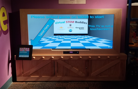 Large screen television with a tablet displaying a game.